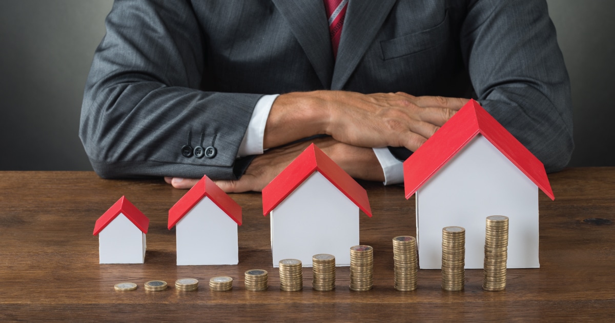 man looking at different house prices