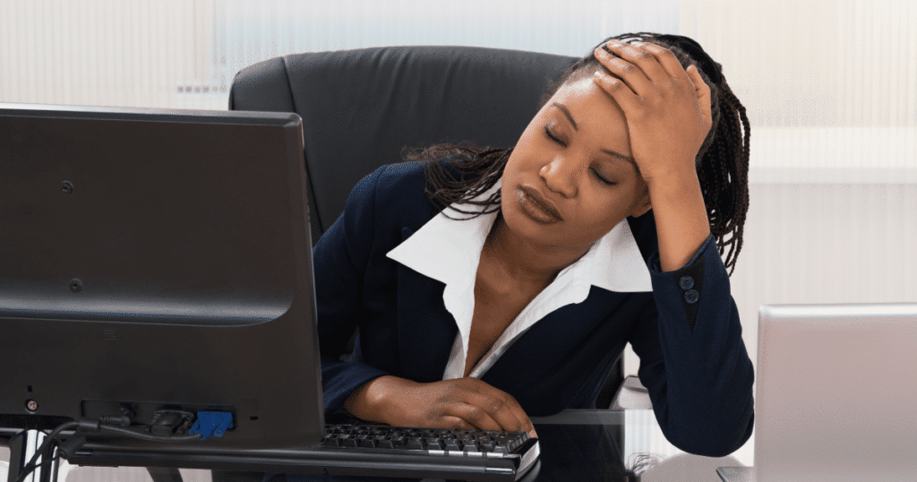 woman seated at her desk feeling frustrated