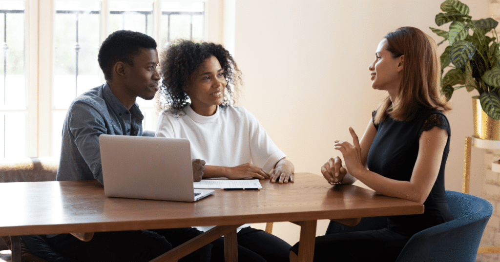 real estate agent advising young couple on investing in real estate